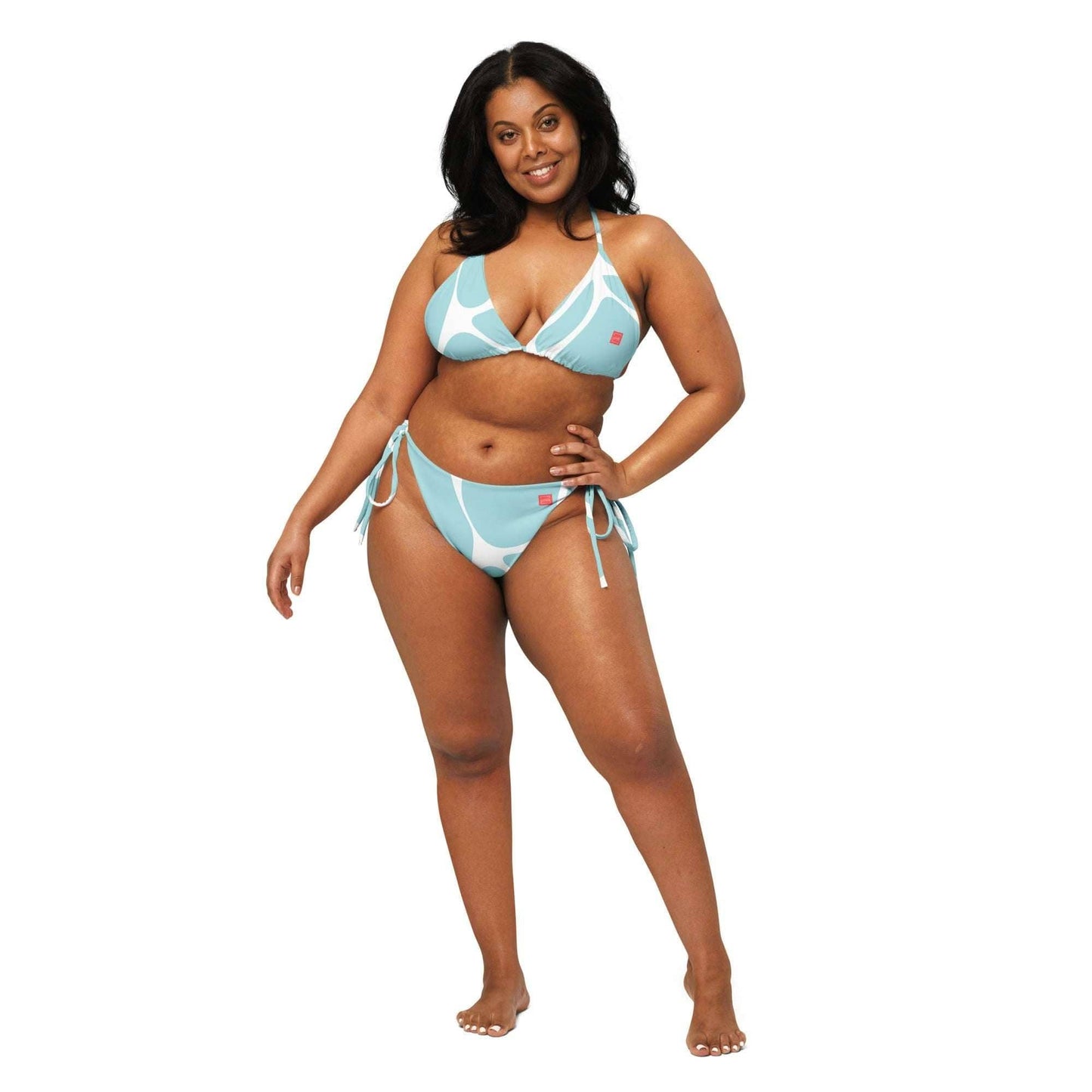 Curvy woman wearing a blue and white ethical fashion bikini by unik.fashion with triangle top and side-tie bottoms
