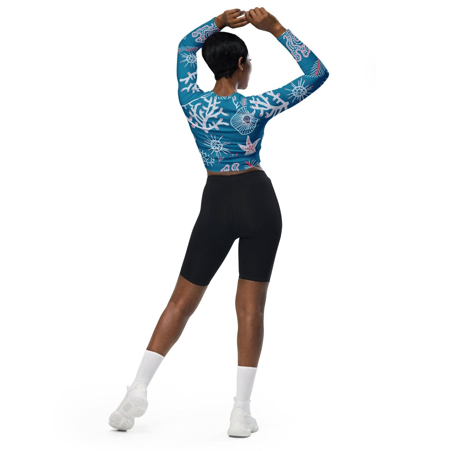 Woman wearing a blue eco-friendly fashion top with white patterns and black shorts from unik.fashion