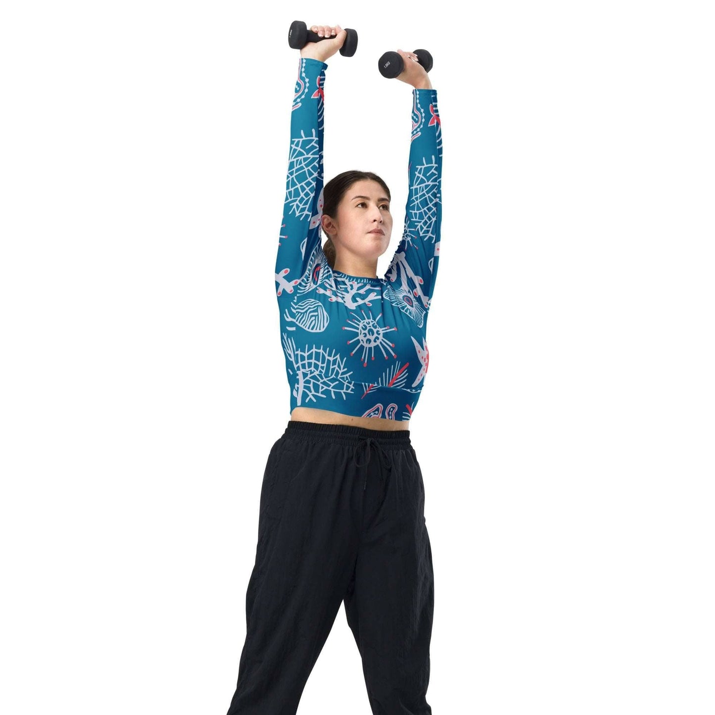 Woman wearing a blue patterned eco-friendly fashion top lifting dumbbells with black pants