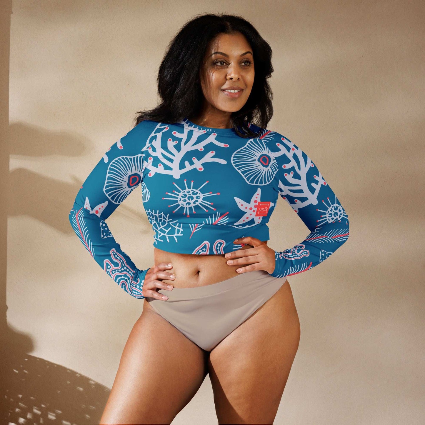 Woman wearing a blue eco-friendly fashion top with coral reef print and long sleeves